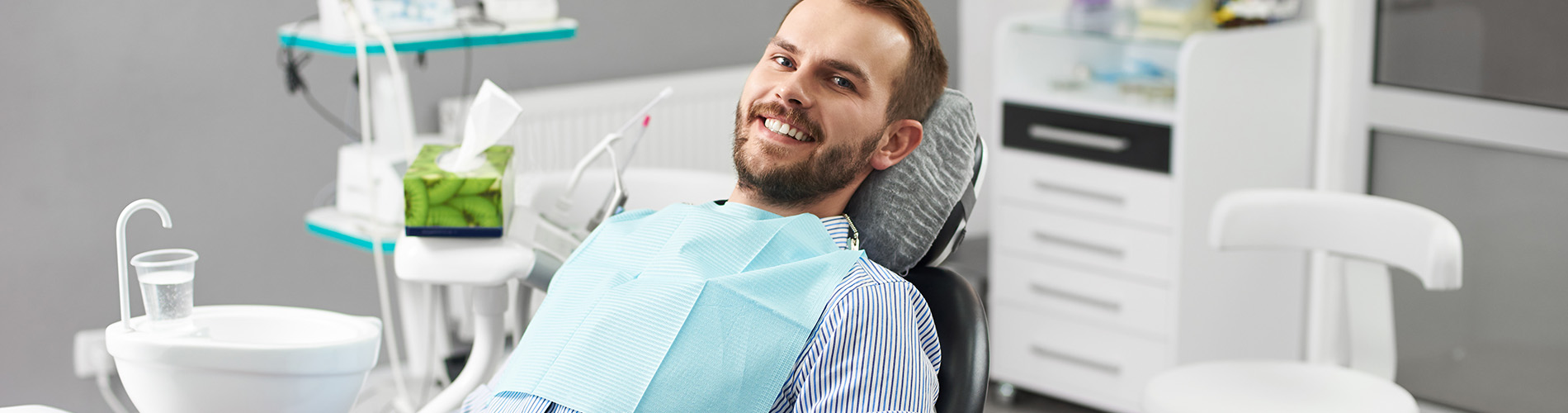 A well-lit reception area with a desk, computer monitor, and potted plant.