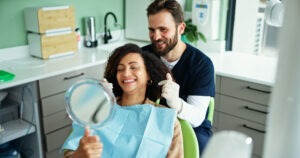 Clinic, happy and dentist with woman with mirror for consulting, teeth whitening and wellness. Healthcare, dentistry and man with patient smile for dental hygiene, oral cleaning and medical services.